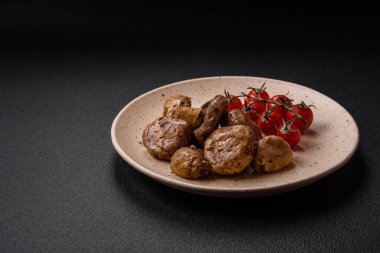 Izgarada pişirilmiş lezzetli sulu şampiyonlar koyu beton arka planda seramik tabakta tuz ve baharatlarla.