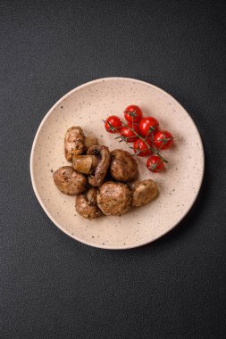 Izgarada pişirilmiş lezzetli sulu şampiyonlar koyu beton arka planda seramik tabakta tuz ve baharatlarla.