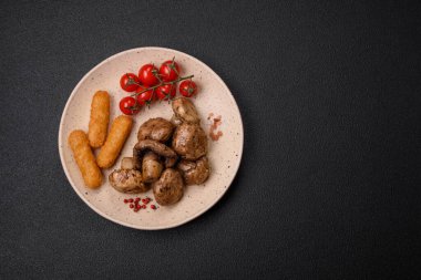 Izgarada pişirilmiş lezzetli sulu şampiyonlar koyu beton arka planda seramik tabakta tuz ve baharatlarla.