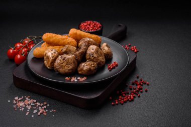 Izgarada pişirilmiş lezzetli sulu şampiyonlar koyu beton arka planda seramik tabakta tuz ve baharatlarla.