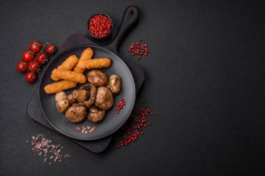 Izgarada pişirilmiş lezzetli sulu şampiyonlar koyu beton arka planda seramik tabakta tuz ve baharatlarla.