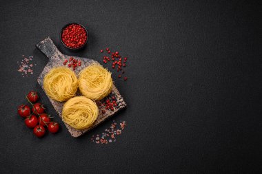 Çiğ capellini makarna ya da koyu beton arka planda tuzlu ve baharatlı erişte.