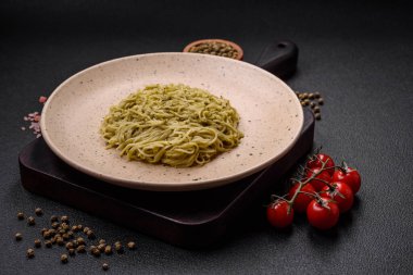 Kapellini makarna ya da pesto soslu erişte, tuz ve baharatlar koyu beton arka planda.