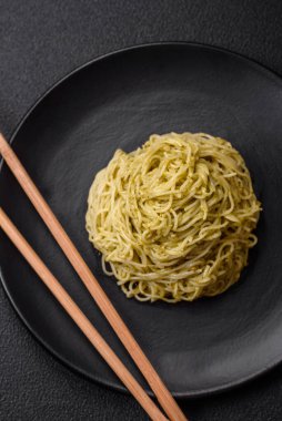 Kapellini makarna ya da pesto soslu erişte, tuz ve baharatlar koyu beton arka planda.