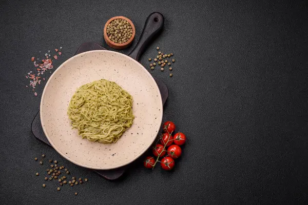 Kapellini makarna ya da pesto soslu erişte, tuz ve baharatlar koyu beton arka planda.