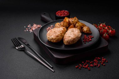 Lezzetli taze tavuk pirzolası ya da koyu beton arka planda tuz, baharat ve otlu köfte.