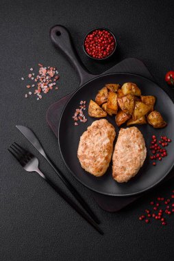 Lezzetli taze tavuk pirzolası ya da koyu beton arka planda tuz, baharat ve otlu köfte.