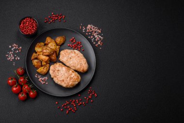 Lezzetli taze tavuk pirzolası ya da koyu beton arka planda tuz, baharat ve otlu köfte.