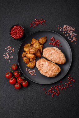 Lezzetli taze tavuk pirzolası ya da koyu beton arka planda tuz, baharat ve otlu köfte.