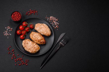 Lezzetli taze tavuk pirzolası ya da koyu beton arka planda tuz, baharat ve otlu köfte.