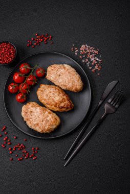 Lezzetli taze tavuk pirzolası ya da koyu beton arka planda tuz, baharat ve otlu köfte.