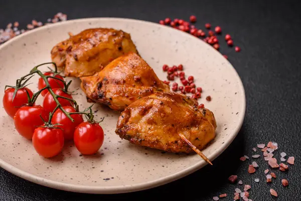 Delicious fresh chicken kebab with salt, spices and herbs on a dark concrete background