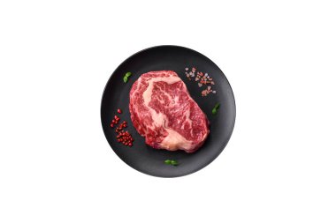 Taze, sulu, çiğ biftek, tuzlu ve baharatlı, koyu beton bir arka planda.