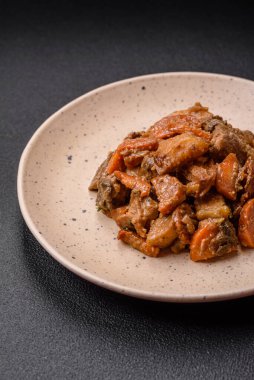 Lezzetli sebze güveci, patates, sığır eti, mantar, havuç, tuz, baharat ve otlar koyu beton arka planda.