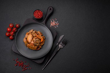 Lezzetli sebze güveci, patates, sığır eti, mantar, havuç, tuz, baharat ve otlar koyu beton arka planda.