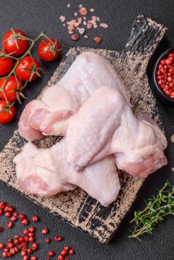 Taze çiğ tavuk kanatları. Tuz ve baharatlarla. Koyu beton bir arka planda pişirmeye hazır.