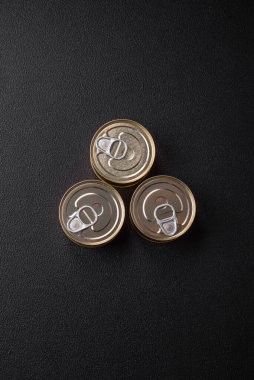 Konserve balıklı yuvarlak metal teneke kutu ya da beton desenli arka planda anahtarı olan et.