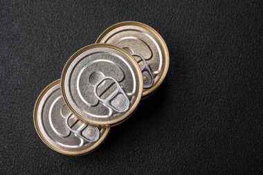 Konserve balıklı yuvarlak metal teneke kutu ya da beton desenli arka planda anahtarı olan et.