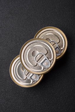 Konserve balıklı yuvarlak metal teneke kutu ya da beton desenli arka planda anahtarı olan et.