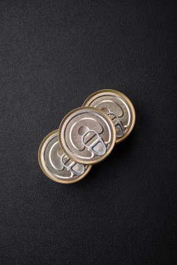 Konserve balıklı yuvarlak metal teneke kutu ya da beton desenli arka planda anahtarı olan et.