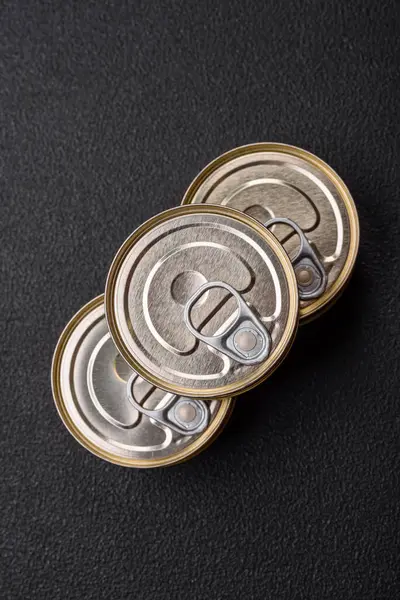 Konserve balıklı yuvarlak metal teneke kutu ya da beton desenli arka planda anahtarı olan et.