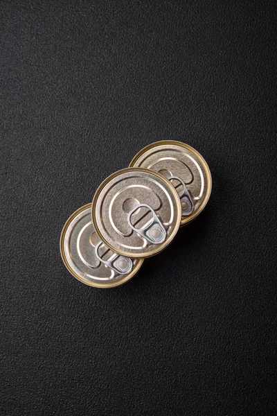 Konserve balıklı yuvarlak metal teneke kutu ya da beton desenli arka planda anahtarı olan et.