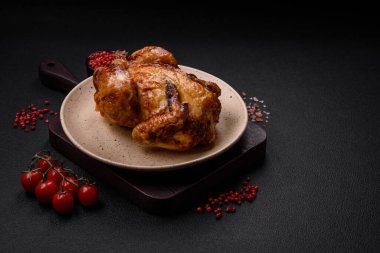 Koyu beton bir arka planda sebzeli, tuzlu ve baharatlı kızarmış tavuk.