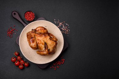 Koyu beton bir arka planda sebzeli, tuzlu ve baharatlı kızarmış tavuk.