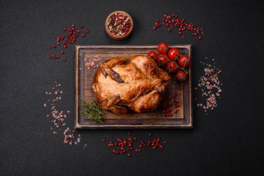 Koyu beton bir arka planda sebzeli, tuzlu ve baharatlı kızarmış tavuk.