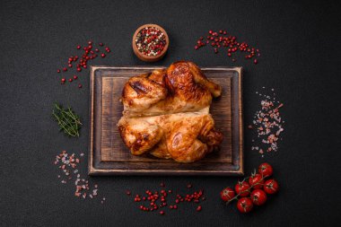 Koyu beton bir arka planda sebzeli, tuzlu ve baharatlı kızarmış tavuk.