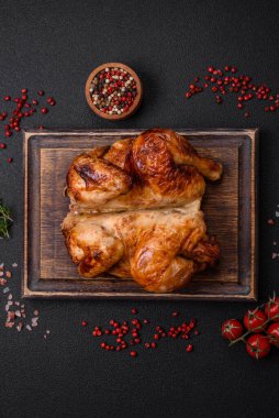 Koyu beton bir arka planda sebzeli, tuzlu ve baharatlı kızarmış tavuk.