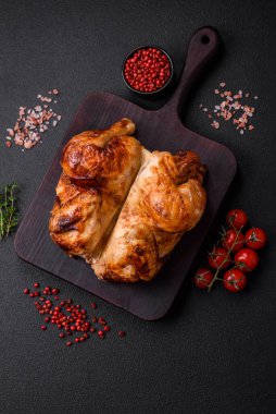 Koyu beton bir arka planda sebzeli, tuzlu ve baharatlı kızarmış tavuk.