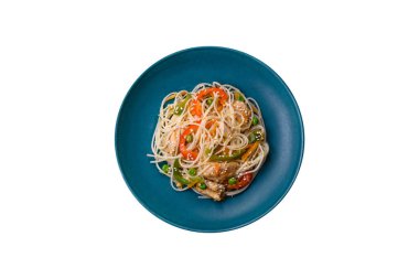 Lezzetli Asya yemekleri pilav eriştesi, tavuk, kuşkonmaz, biber, susam tohumu ve soya sosu ile koyu beton arka planda.