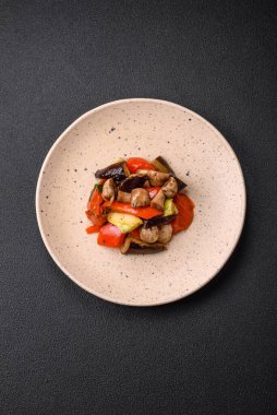 Izgara sebze, domates, mantar, tatlı biber, patlıcan, kabak, tuz, baharat ve seramik tabakta bitkilerden oluşan lezzetli bir salata.