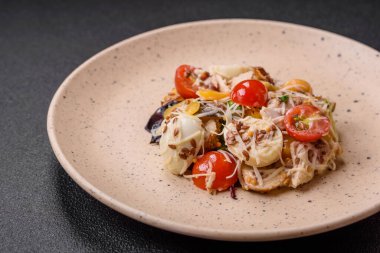 Tavuklu taze salata, bıldırcın yumurtası, kiraz domatesleri, marul, tuz ve baharatlar koyu beton arka planda.