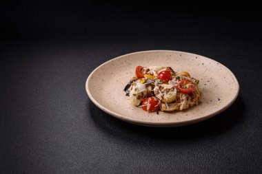 Tavuklu taze salata, bıldırcın yumurtası, kiraz domatesleri, marul, tuz ve baharatlar koyu beton arka planda.