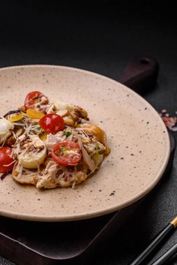 Tavuklu taze salata, bıldırcın yumurtası, kiraz domatesleri, marul, tuz ve baharatlar koyu beton arka planda.