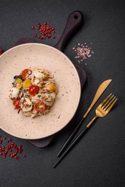 Tavuklu taze salata, bıldırcın yumurtası, kiraz domatesleri, marul, tuz ve baharatlar koyu beton arka planda.