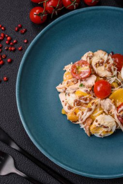 Tavuklu taze salata, bıldırcın yumurtası, kiraz domatesleri, marul, tuz ve baharatlar koyu beton arka planda.