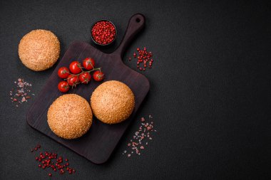 Lezzetli taze beyaz yuvarlak ekmek. Koyu beton arka planda tohumlar ve tahıllar var.