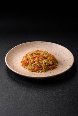 Koyu beton arka planda tavuk, havuç, böğürtlen, baharat ve bitkilerle nefis Özbek pilavı