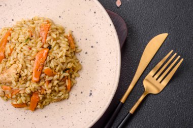 Koyu beton arka planda tavuk, havuç, böğürtlen, baharat ve bitkilerle nefis Özbek pilavı