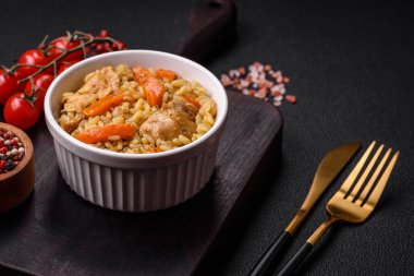 Koyu beton arka planda tavuk, havuç, böğürtlen, baharat ve bitkilerle nefis Özbek pilavı