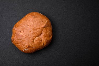 Koyu beton bir arka planda tohumları ve tahılları olan lezzetli çıtır çıtır kahverengi ekmek.