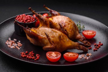 Kavrulmuş bıldırcın, keklik ya da portakalla doldurulmuş koyu beton arka planda baharat ve otlarla dolu güvercin.