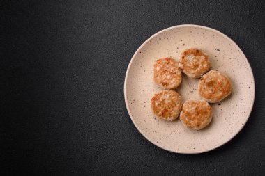 Kızarmış et köftesi, domuz eti ya da tuzlu tavuk, baharat ve ottan oluşan koyu beton bir arka planda.