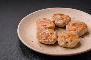 Kızarmış et köftesi, domuz eti ya da tuzlu tavuk, baharat ve ottan oluşan koyu beton bir arka planda.