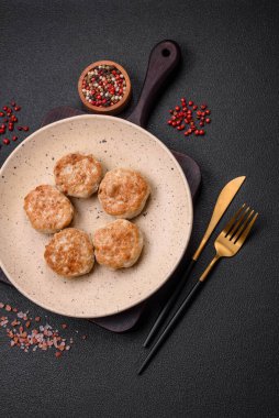 Kızarmış et köftesi, domuz eti ya da tuzlu tavuk, baharat ve ottan oluşan koyu beton bir arka planda.