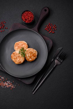 Kızarmış et köftesi, domuz eti ya da tuzlu tavuk, baharat ve ottan oluşan koyu beton bir arka planda.