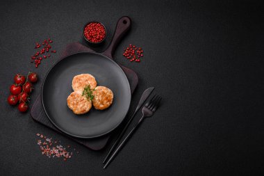 Kızarmış et köftesi, domuz eti ya da tuzlu tavuk, baharat ve ottan oluşan koyu beton bir arka planda.